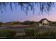 Charming community building at twilight with lush landscaping and mountain views at 1956 W Kinfield Trl, Phoenix, AZ 85085
