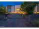 Modern home exterior showcasing clean lines, a gated yard, and evening ambiance at 1956 W Kinfield Trl, Phoenix, AZ 85085