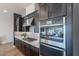 Modern kitchen featuring stainless steel appliances, dark cabinetry, and patterned backsplash for a sleek and stylish design at 1956 W Kinfield Trl, Phoenix, AZ 85085