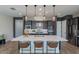 Contemporary kitchen featuring a large island with seating, stainless appliances, dark cabinets, and pendant lighting at 1956 W Kinfield Trl, Phoenix, AZ 85085