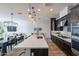 Open-concept kitchen with a large island, pendant lighting, and dark cabinets, seamlessly connected to the dining area at 1956 W Kinfield Trl, Phoenix, AZ 85085