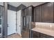 Well-equipped kitchen with stainless steel refrigerator, white countertops, dark cabinetry, and a conveniently located pantry door at 1956 W Kinfield Trl, Phoenix, AZ 85085