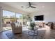 Bright living area features a sliding door with backyard views, modern ceiling fan, and stylish decor at 1956 W Kinfield Trl, Phoenix, AZ 85085
