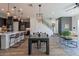 Open-concept living and dining area with stylish furnishings, wood-look tile flooring, and modern lighting fixtures at 1956 W Kinfield Trl, Phoenix, AZ 85085