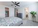 Bright bedroom with a patterned bedspread, ceiling fan, and views to the walk-in closet and bathroom at 1956 W Kinfield Trl, Phoenix, AZ 85085