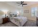 Comfortable bedroom featuring a well-lit space with plantation shutters and ceiling fan at 1956 W Kinfield Trl, Phoenix, AZ 85085