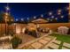 Beautiful outdoor patio featuring a cozy fireplace, umbrella, comfortable seating, and stylish landscaping at 1956 W Kinfield Trl, Phoenix, AZ 85085