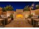 Serene patio area with a stone fireplace, cozy seating, and string lights, creating a relaxing outdoor space at 1956 W Kinfield Trl, Phoenix, AZ 85085