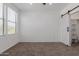 Bedroom features neutral carpet, bright natural light, and a barn door to a closet at 20100 N 78Th Pl # 2114, Scottsdale, AZ 85255