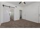 Bedroom features neutral carpet, a ceiling fan, and barn door to the ensuite bathroom at 20100 N 78Th Pl # 2114, Scottsdale, AZ 85255