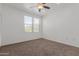 This bedroom features neutral walls, carpeting, a ceiling fan, and bright natural light at 20100 N 78Th Pl # 2114, Scottsdale, AZ 85255