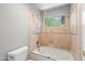 Close up view of the bathroom with bathtub and shower with travertine tile and a window at 2024 N 125Th Ave, Avondale, AZ 85392