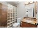 Bathroom featuring a glass block shower wall, a granite countertop, and wood cabinet at 2024 N 125Th Ave, Avondale, AZ 85392