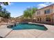 Backyard view with a large swimming pool and a spa, surrounded by greenery and a two-story house at 2024 N 125Th Ave, Avondale, AZ 85392
