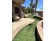 Lush backyard with manicured landscaping, stone accents, and covered patio at 20332 N Denizen Dr, Surprise, AZ 85387