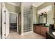 Modern bathroom with tile floors, wood cabinet vanity, and glass block wall at 20332 N Denizen Dr, Surprise, AZ 85387