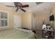 Bedroom with a leather headboard, a ceiling fan, and an open door, with an ironing board on the right at 20332 N Denizen Dr, Surprise, AZ 85387