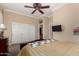 Bedroom with a leather headboard, a ceiling fan, and white double closet doors at 20332 N Denizen Dr, Surprise, AZ 85387