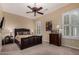 Bedroom featuring a leather headboard, ceiling fan, and shuttered windows providing natural light at 20332 N Denizen Dr, Surprise, AZ 85387