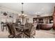 Open concept dining area featuring elegant chandelier, tan tile floor and views to the kitchen and living room at 20332 N Denizen Dr, Surprise, AZ 85387