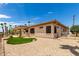 Back exterior view showing covered patio, gravel landscaping, and desert surroundings at 20332 N Denizen Dr, Surprise, AZ 85387