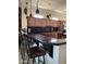 A kitchen features dark wood cabinets, a black tile backsplash, granite countertops, and a counter with barstool seating at 20332 N Denizen Dr, Surprise, AZ 85387