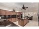 Open kitchen with dark countertops, tile backsplash, wood cabinets and a kitchen island at 20332 N Denizen Dr, Surprise, AZ 85387