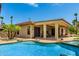 Inviting backyard oasis featuring a large pool with rock accents, covered patio, and desert landscaping at 20332 N Denizen Dr, Surprise, AZ 85387