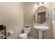 Elegant powder room with pedestal sink, oval mirror, and neutral color palette at 20332 N Denizen Dr, Surprise, AZ 85387