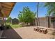 Landscaped backyard with a storage shed, fire pit, patio cover, and a gravel ground cover at 2202 S Lawther Dr, Apache Junction, AZ 85120