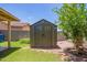 Outdoor shed with double doors and a peak roof in a well-maintained backyard with a tree at 2202 S Lawther Dr, Apache Junction, AZ 85120