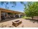 Spacious backyard patio featuring a brick fire pit, outdoor seating, and lush greenery at 2202 S Lawther Dr, Apache Junction, AZ 85120