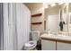 Cozy bathroom with a neutral color scheme, decorative shelves, shower curtain, and a toilet with patriotic seat cover at 2202 S Lawther Dr, Apache Junction, AZ 85120
