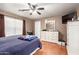 Comfortable bedroom with hardwood floors, ceiling fan and a large dresser with mirror at 2202 S Lawther Dr, Apache Junction, AZ 85120