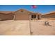 Charming single-story home with a two-car garage and well-kept desert landscaping, flying an American flag at 2202 S Lawther Dr, Apache Junction, AZ 85120