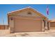 A tan home featuring a two-car garage and desert landscaping in the front at 2202 S Lawther Dr, Apache Junction, AZ 85120