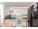 Functional kitchen with white cabinets, tile countertops, and modern appliances for easy meal preparation at 2202 S Lawther Dr, Apache Junction, AZ 85120