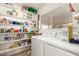 Practical laundry room equipped with washer, dryer, and ample shelving for storage at 2202 S Lawther Dr, Apache Junction, AZ 85120