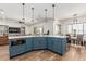 Stylish kitchen island with blue cabinetry, quartz countertops, and pendant lighting, open to living spaces at 22414 W Meade Ln, Buckeye, AZ 85326