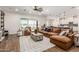 A spacious living room showcases a large sectional sofa, stylish coffee table, and abundant natural light at 22414 W Meade Ln, Buckeye, AZ 85326