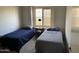 Cozy bedroom featuring twin beds with soft lighting from the window at 2723 E Rockledge Rd, Phoenix, AZ 85048