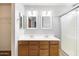 Main bathroom with double vanity sinks, wood cabinets, decorative mirrors, and glass shower at 3025 E Fremont Rd, Phoenix, AZ 85042