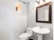 Powder room featuring pedestal sink, decorative mirror and fixtures, and a small window at 3025 E Fremont Rd, Phoenix, AZ 85042