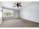 Spacious bedroom with neutral carpet, ceiling fan, and a large window for natural light at 3025 E Fremont Rd, Phoenix, AZ 85042