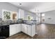 Bright kitchen with white cabinets, tile backsplash, and open floor plan to living area at 3025 E Fremont Rd, Phoenix, AZ 85042