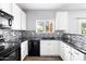 Well-lit kitchen featuring white cabinets, black appliances, and mosaic tile backsplash at 3025 E Fremont Rd, Phoenix, AZ 85042