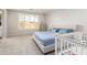 Cozy bedroom with a large window, a queen bed with pillows, and a crib at 32611 N 20Th Dr, Phoenix, AZ 85085