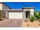 Modern home featuring a two-car garage, desert landscaping, and a neutral color palette under a clear blue sky at 32611 N 20Th Dr, Phoenix, AZ 85085