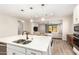 Modern kitchen island with stainless steel sink, quartz countertop and pendant lighting open to the living room at 32611 N 20Th Dr, Phoenix, AZ 85085