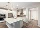 Open kitchen with white cabinets, stainless steel appliances, a spacious island and wood-look tile flooring at 32611 N 20Th Dr, Phoenix, AZ 85085